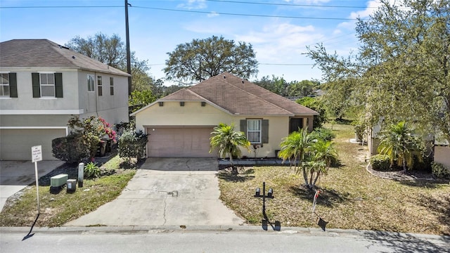 view of front facade with stucco siding, driveway, and a garage