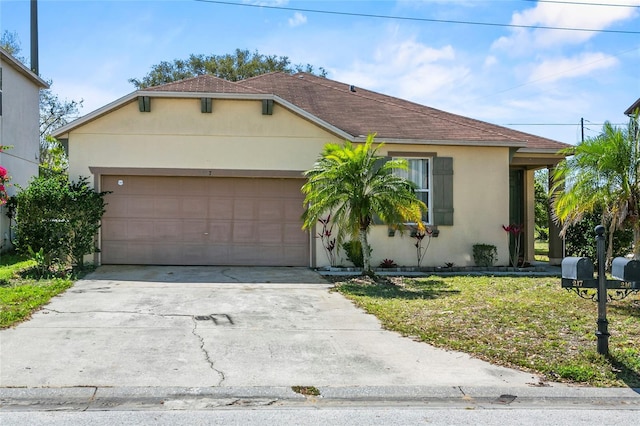 view of front of property featuring stucco siding, driveway, a front lawn, and a garage