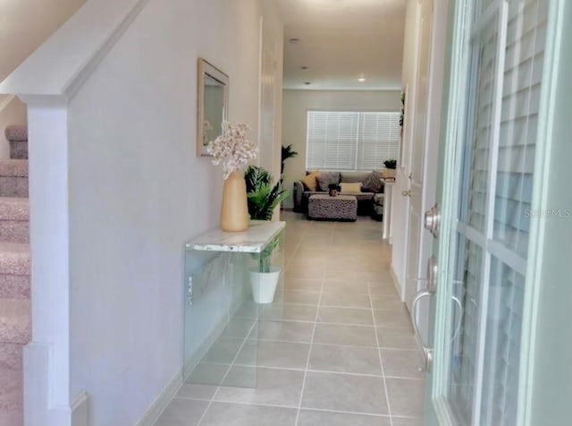 hallway featuring stairs and light tile patterned flooring