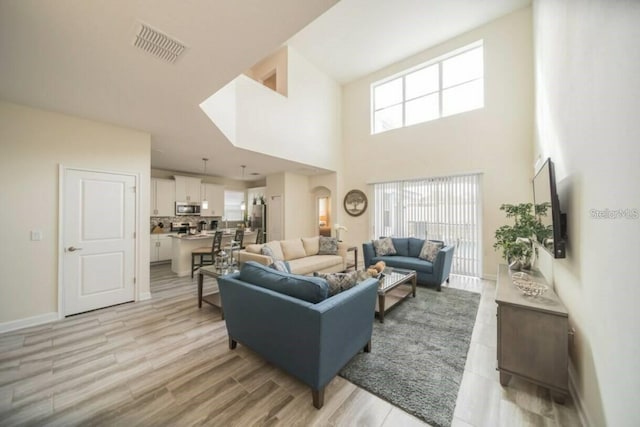 1646 Moon Valley Dr, Davenport, FL 33896 - living room with a healthy amount of sunlight, light wood-type flooring, visible vents, and baseboards