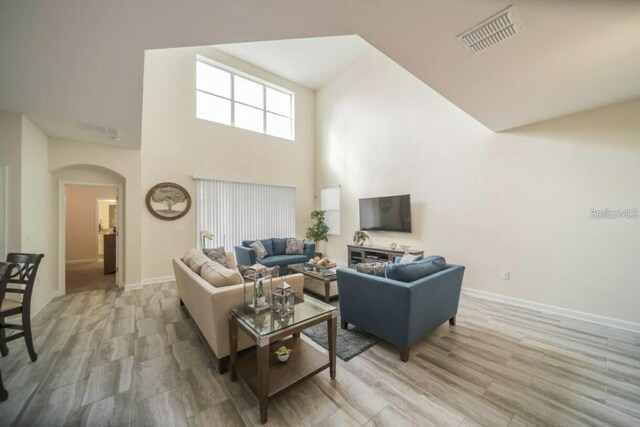 1646 Moon Valley Dr, Davenport, FL 33896 - living area with arched walkways, light wood-style flooring, visible vents, and baseboards