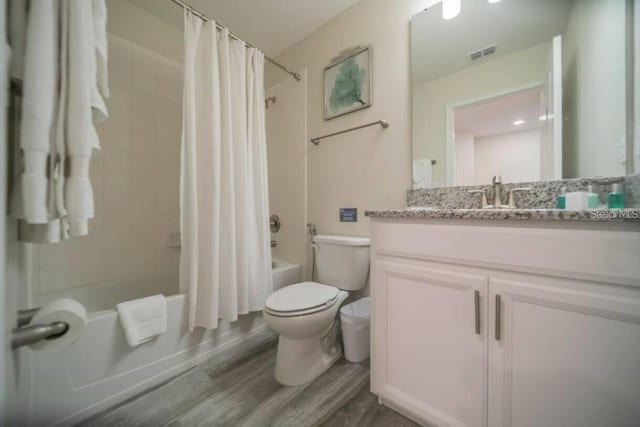 1646 Moon Valley Dr, Davenport, FL 33896 - full bathroom with shower / bath combination with curtain, visible vents, toilet, vanity, and wood finished floors
