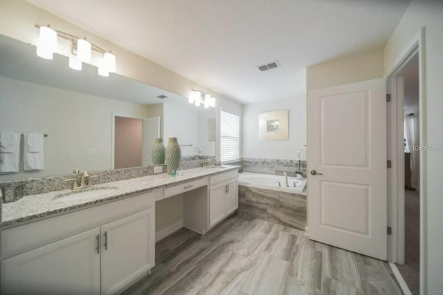 1646 Moon Valley Dr, Davenport, FL 33896 - full bath with double vanity, a garden tub, visible vents, and a sink