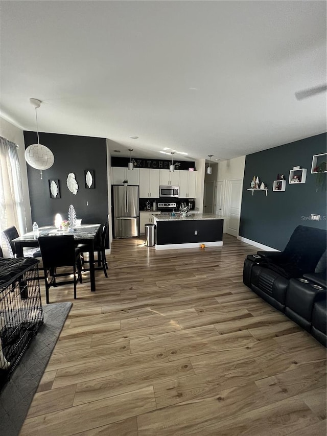 living area featuring baseboards and light wood finished floors