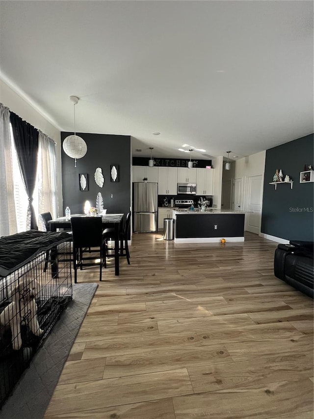 living area with baseboards and light wood finished floors
