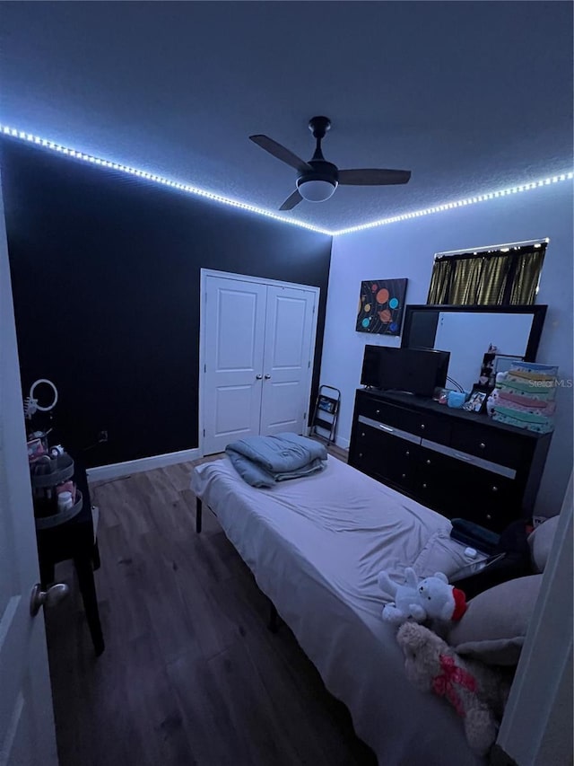 bedroom with a ceiling fan, baseboards, and wood finished floors