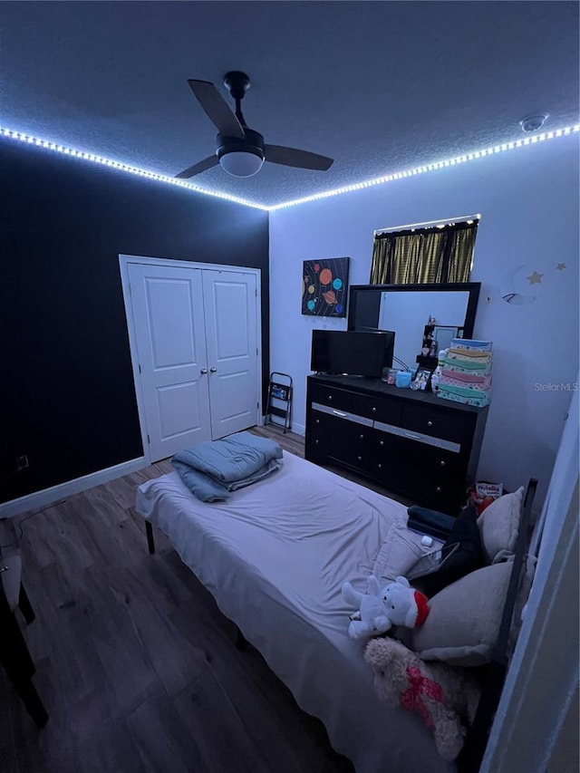 bedroom featuring a ceiling fan, baseboards, and wood finished floors