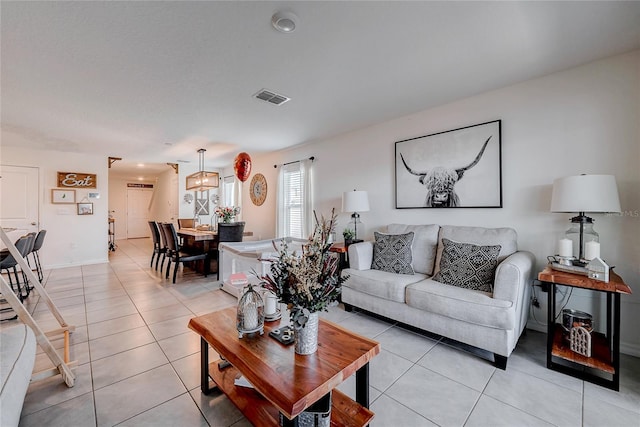 living room with visible vents, baseboards, and light tile patterned floors