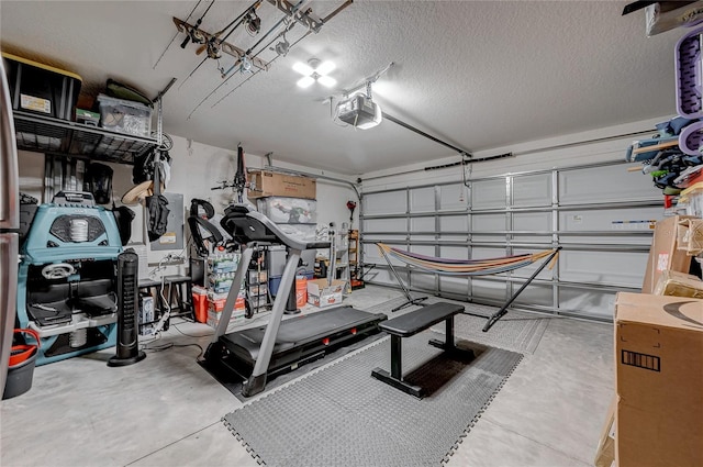 exercise area with a garage and a textured ceiling