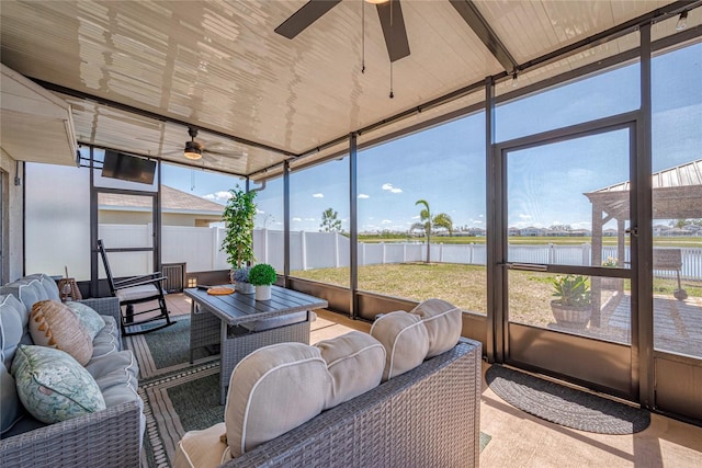 sunroom / solarium featuring a water view and ceiling fan