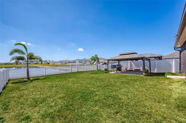 view of yard with a gazebo, a patio, a water view, and a fenced backyard