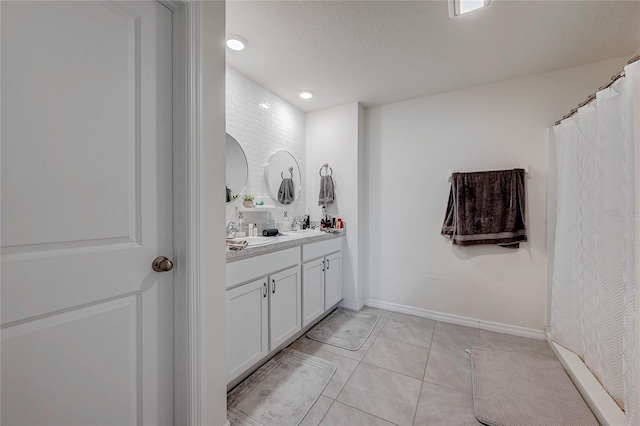 full bathroom featuring tile patterned flooring, vanity, and baseboards