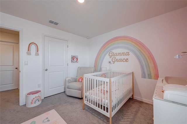 bedroom with a crib, carpet flooring, and visible vents