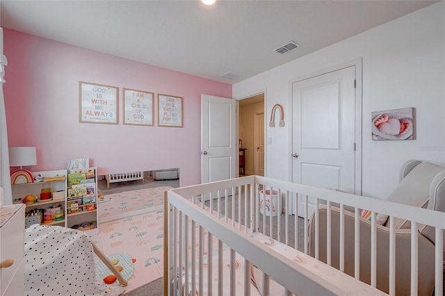 bedroom with a crib and visible vents