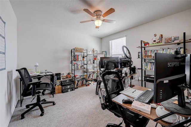 carpeted home office featuring ceiling fan and a textured ceiling