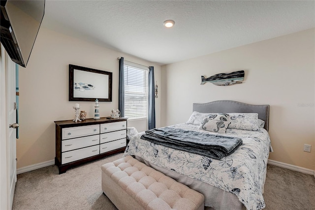 carpeted bedroom featuring a textured ceiling and baseboards