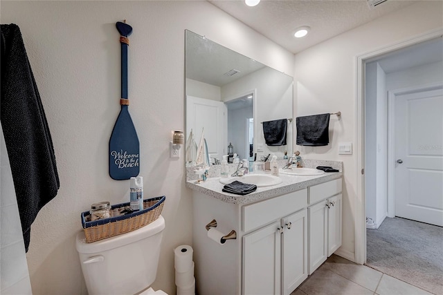 bathroom featuring double vanity, tile patterned flooring, a sink, and toilet