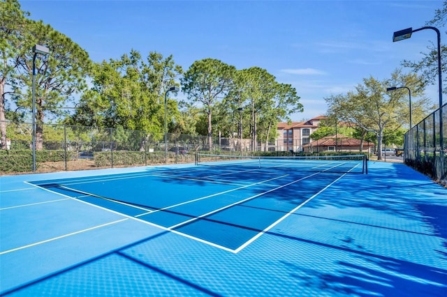 view of tennis court featuring fence