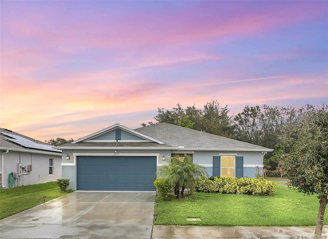 single story home with a garage, a front lawn, concrete driveway, and stucco siding