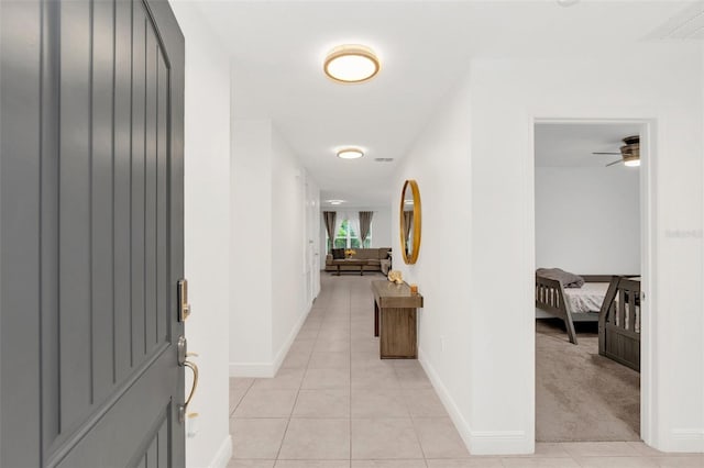 hallway featuring light tile patterned floors and baseboards