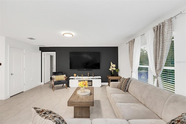 living room with visible vents, baseboards, and light tile patterned floors