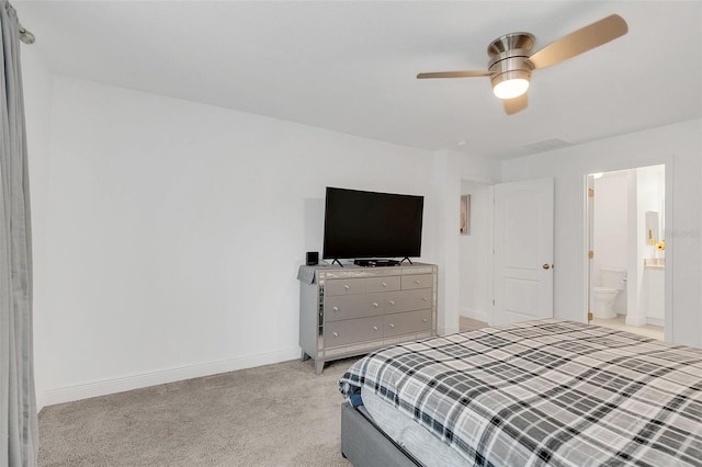 bedroom with light carpet, visible vents, baseboards, a ceiling fan, and ensuite bath