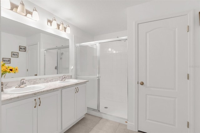 full bathroom featuring a stall shower, a sink, and tile patterned floors