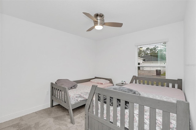 bedroom featuring light carpet, ceiling fan, and baseboards