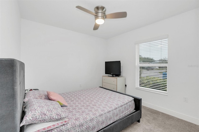 bedroom with light carpet, baseboards, and a ceiling fan