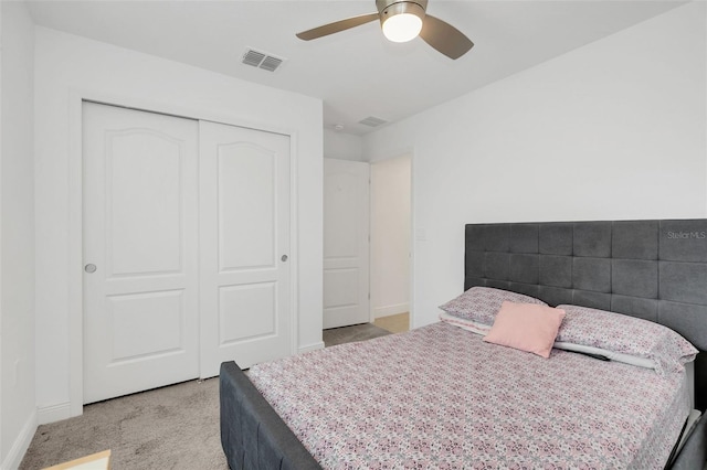 bedroom featuring light carpet, baseboards, visible vents, a ceiling fan, and a closet