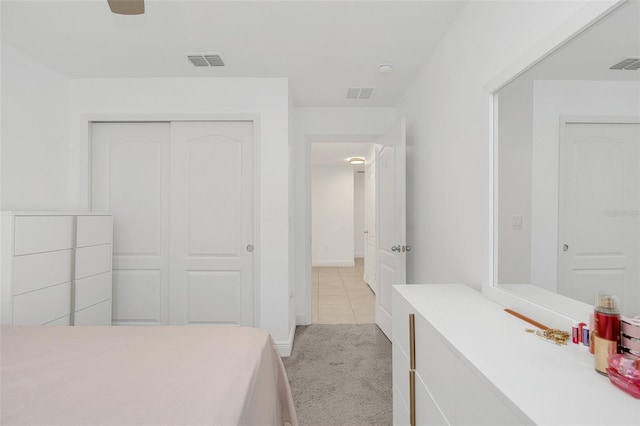 bedroom with light carpet, a closet, and visible vents