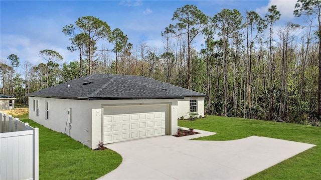 view of property exterior with driveway, a lawn, roof with shingles, fence, and stucco siding