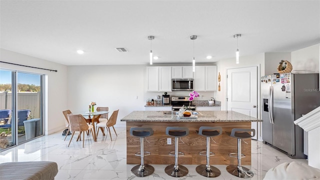 kitchen featuring light stone counters, marble finish floor, visible vents, appliances with stainless steel finishes, and white cabinetry