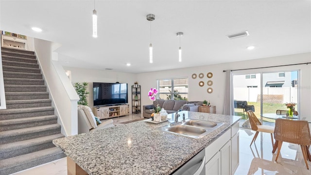 kitchen with visible vents, white cabinets, a sink, and decorative light fixtures