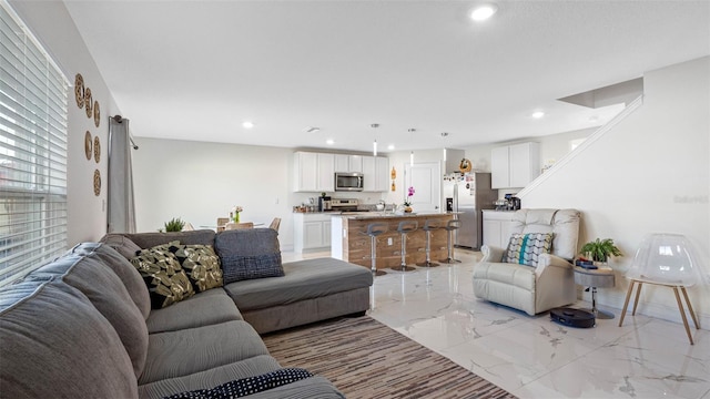 living area with recessed lighting, marble finish floor, and baseboards