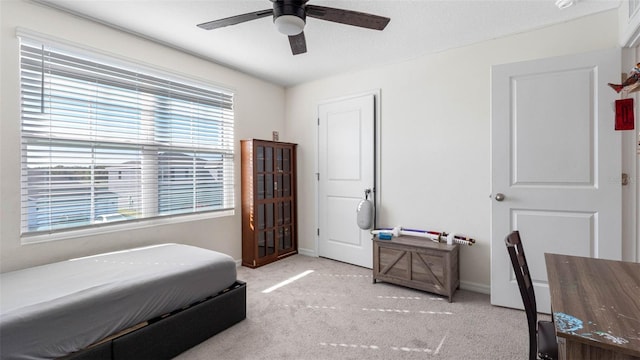 carpeted bedroom featuring ceiling fan and baseboards