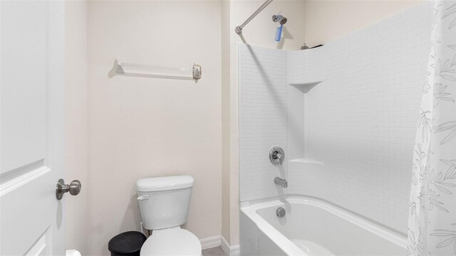 full bath featuring shower / tub combo, baseboards, and toilet