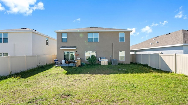 back of house with central air condition unit, stucco siding, a lawn, a patio area, and a fenced backyard