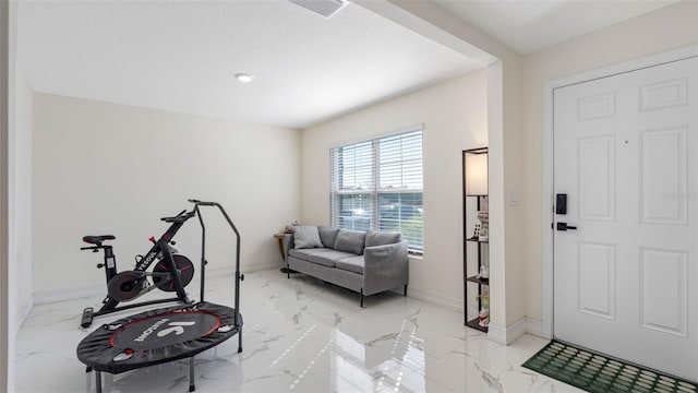 exercise area with marble finish floor, visible vents, and baseboards