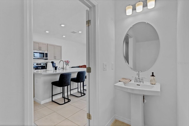 4544 Teoli Ct, Kissimmee, FL 34746 - bathroom with baseboards, visible vents, a sink, and tile patterned floors
