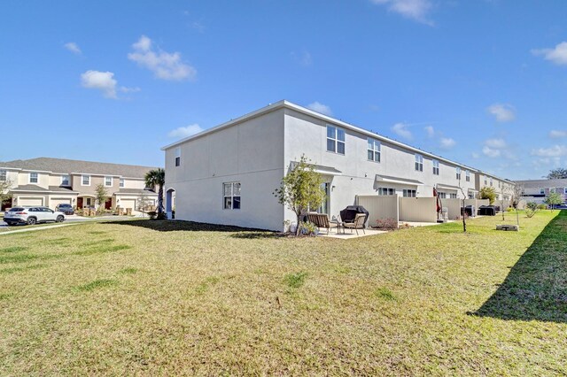 4544 Teoli Ct, Kissimmee, FL 34746 - rear view of property featuring a patio area, a residential view, a lawn, and stucco siding