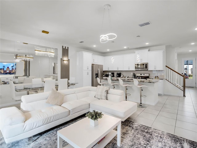 living room featuring light tile patterned floors, visible vents, a notable chandelier, and recessed lighting