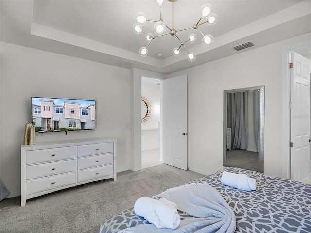 bedroom with a chandelier, light colored carpet, visible vents, baseboards, and a tray ceiling