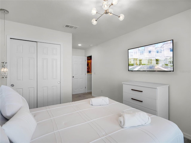 bedroom with a closet, visible vents, and a notable chandelier