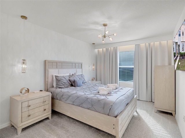 bedroom with a notable chandelier and light colored carpet