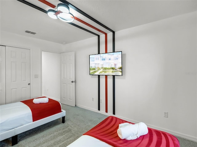 carpeted bedroom with baseboards, visible vents, and a closet