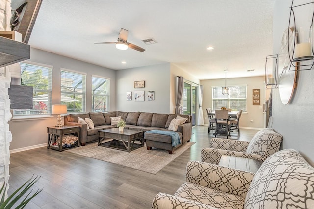 living room featuring a wealth of natural light, light wood-style flooring, and visible vents