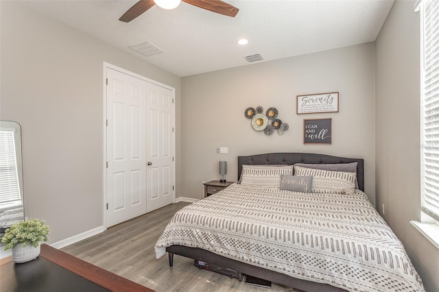 bedroom featuring visible vents, baseboards, light wood-style flooring, ceiling fan, and a closet