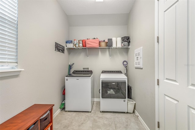 washroom featuring light tile patterned floors, laundry area, independent washer and dryer, and baseboards