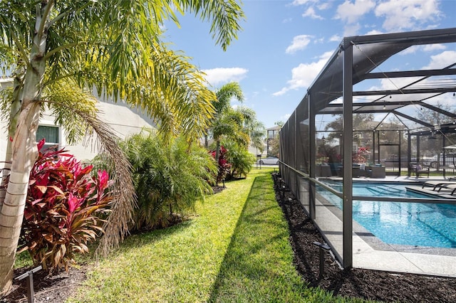 outdoor pool featuring a yard, a patio, and a lanai